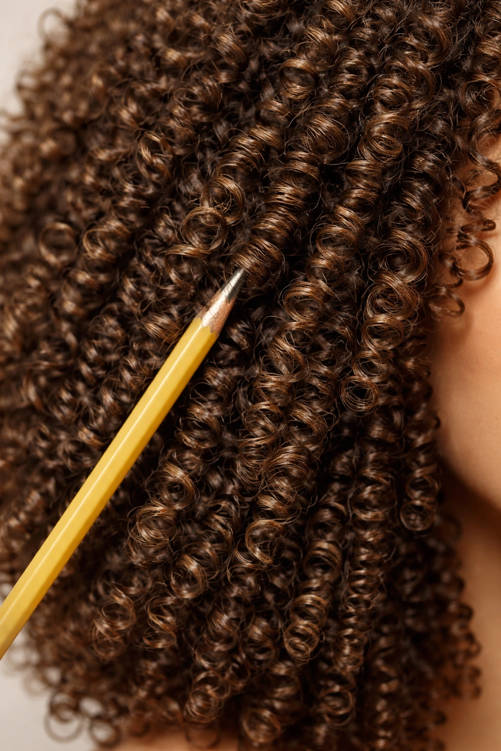 Close-up of tight corkscrew curls with pencil-diameter circumference in 3C hair