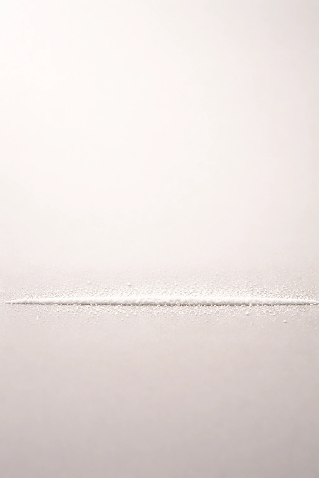 Minimal bottom-line line with subtle powder dusting on a neutral background