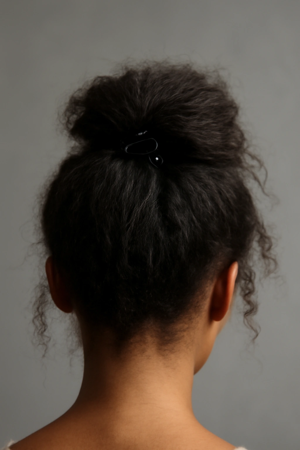 10 Claw Clip Hairstyles That Work for Black Hair 7 Close-up of a tousled high ponytail secured with a claw clip, emphasizing crown lift and texture