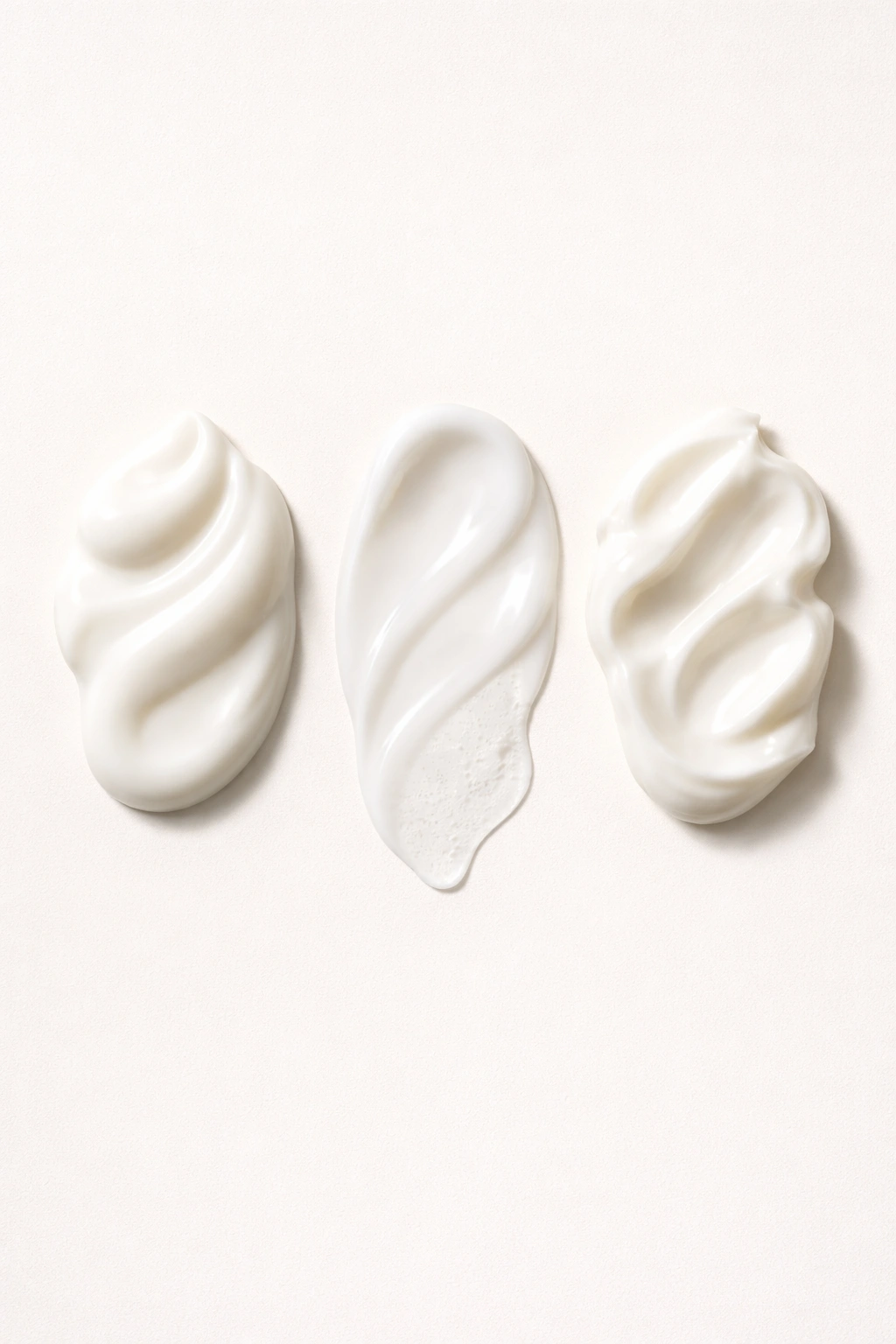 Minimal close-up of three conditioner texture swatches on a neutral background