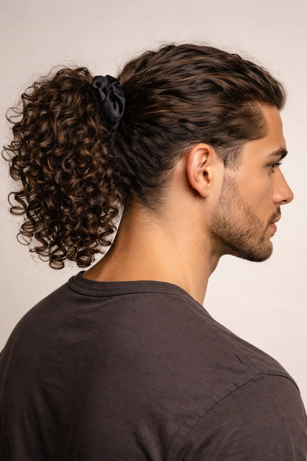 Defined curly ponytail secured with satin scrunchie, showcasing curl texture