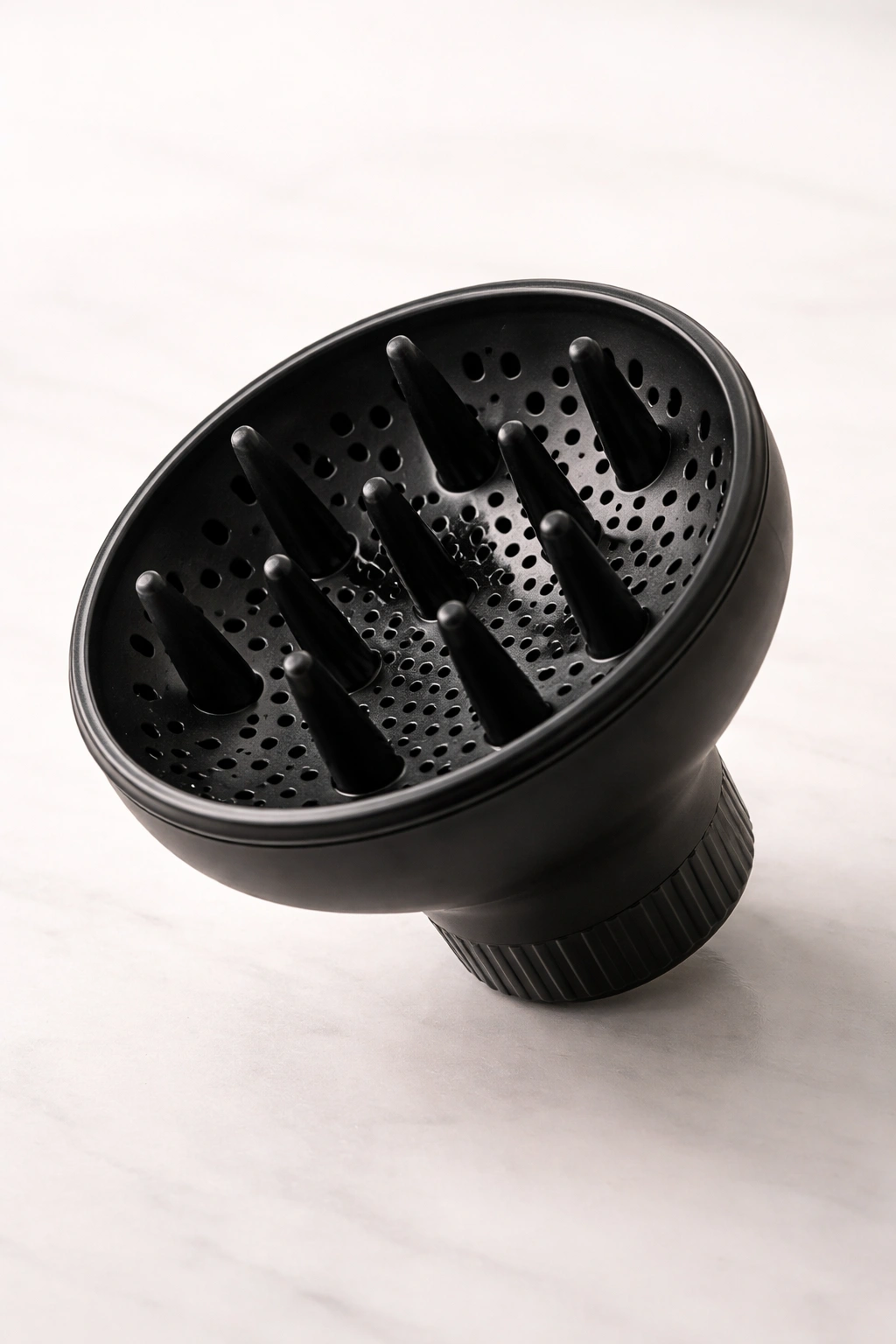 Hair dryer diffuser on a neutral surface with circular bowl and vents