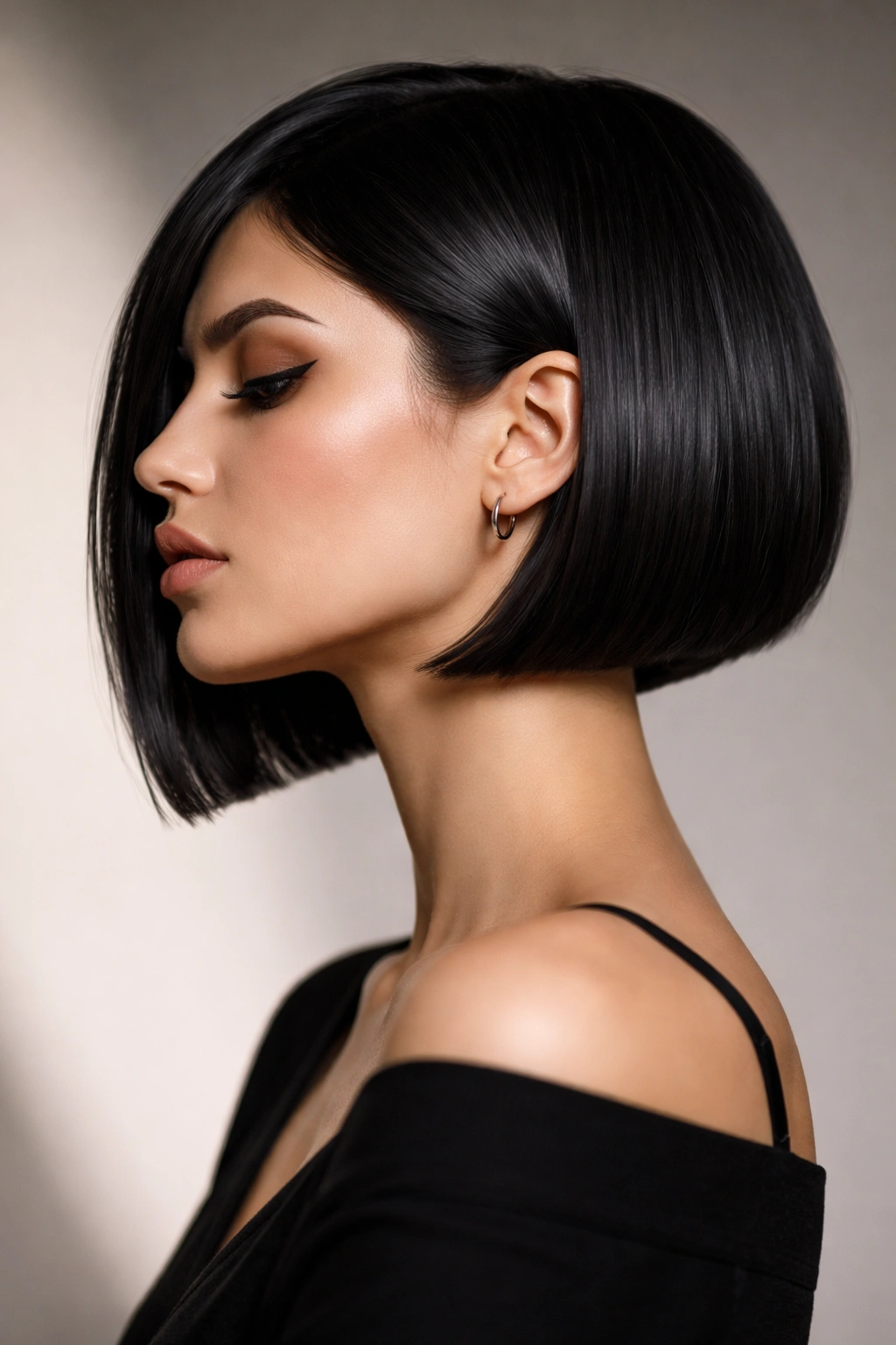 Profile view of a woman with a razor-edged edgy bob in a studio setting, focused on hair silhouette