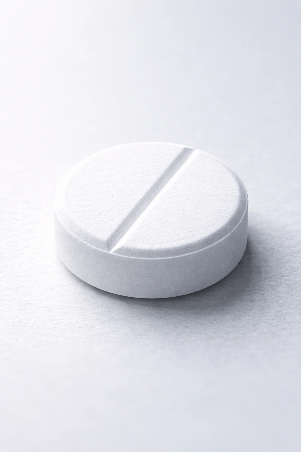 Single white finasteride tablet on neutral surface