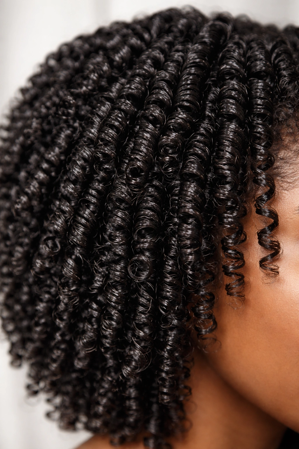 Close-up of defined finger coil curls on damp hair