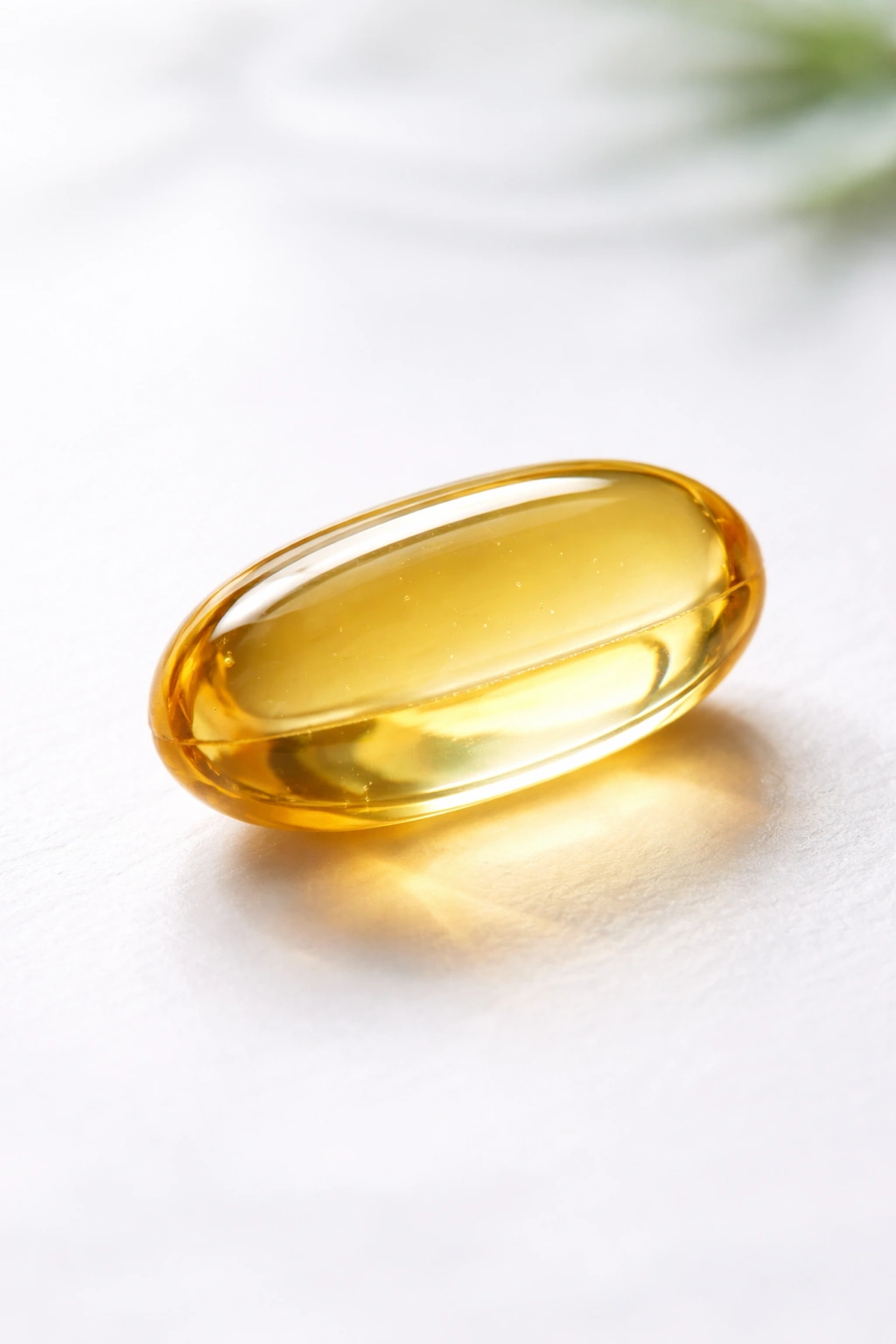 Close-up of a single hair growth supplement capsule on white surface