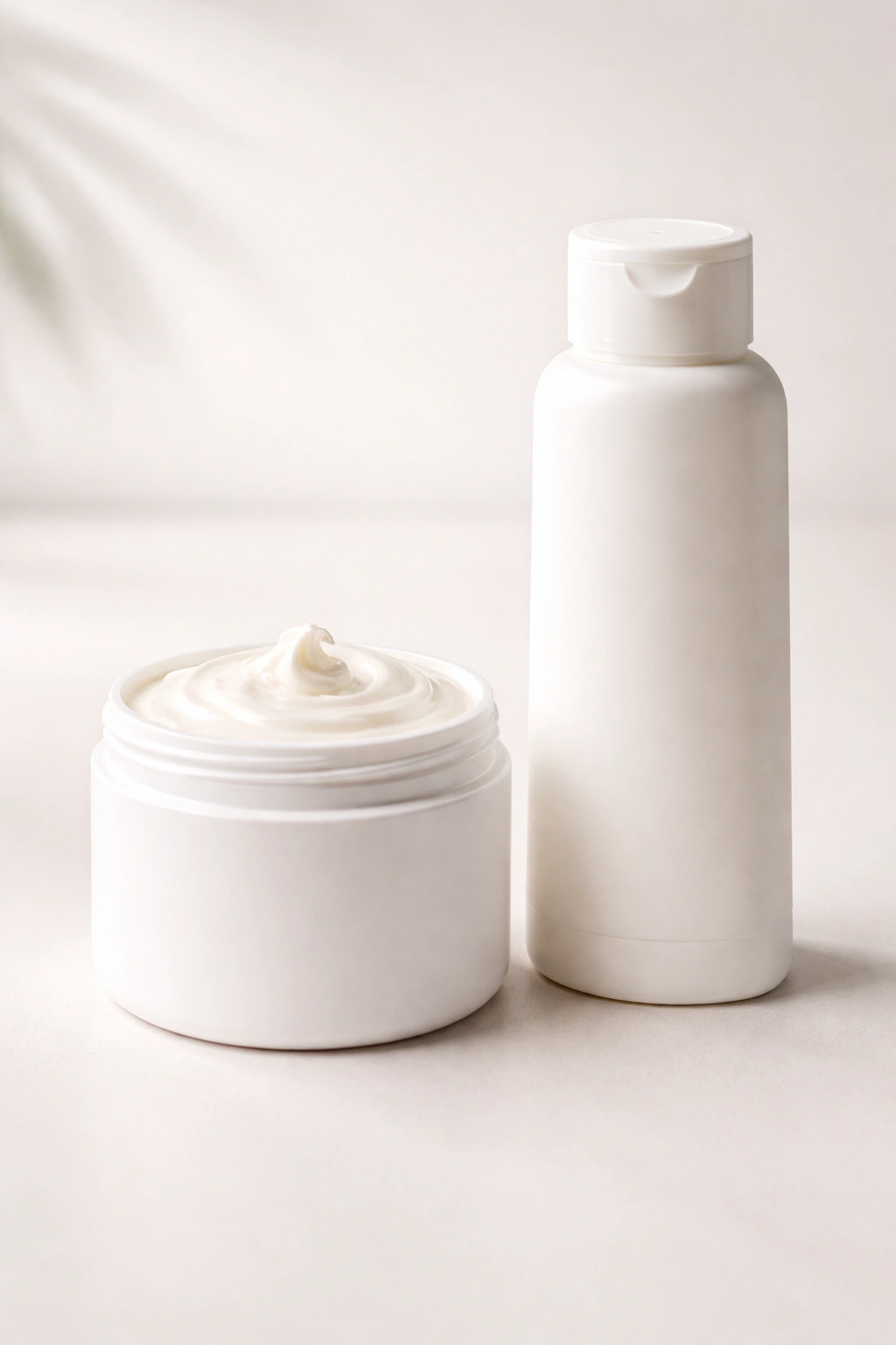 Two containers representing hair mask and conditioner on a plain surface