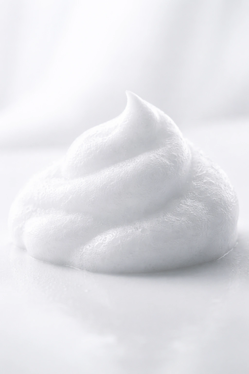 Close-up of airy mousse foam on a white surface showing texture