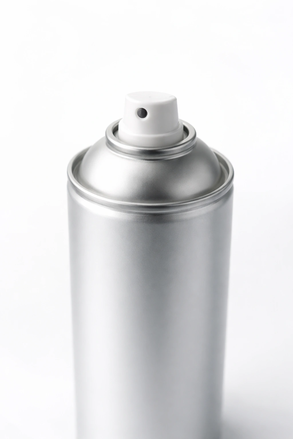 Close-up of a label-free hairspray can on a plain backdrop for hair care visuals