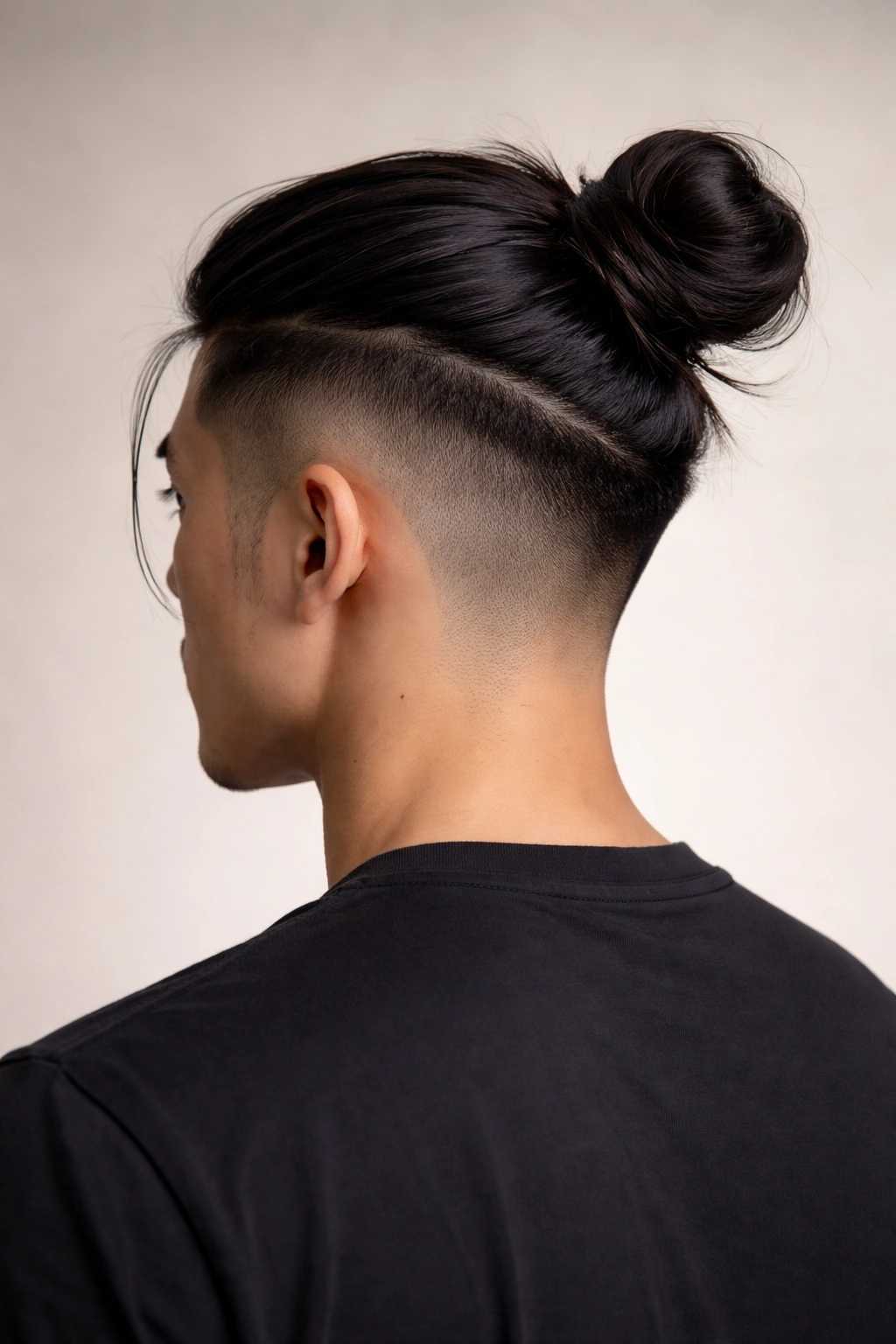 Man bun with undercut showing long top bun and shaved sides