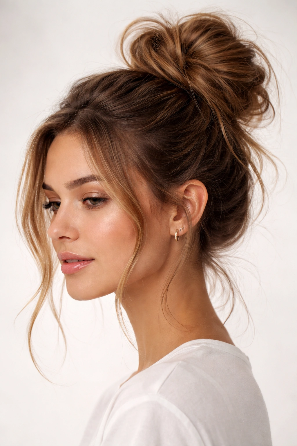 Close-up view of a high messy bun with face-framing pieces.