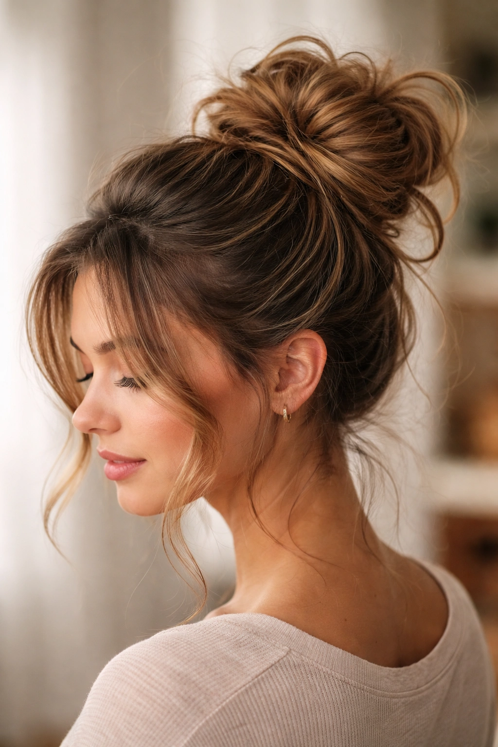Close-up of a textured messy bun with loose strands around the face