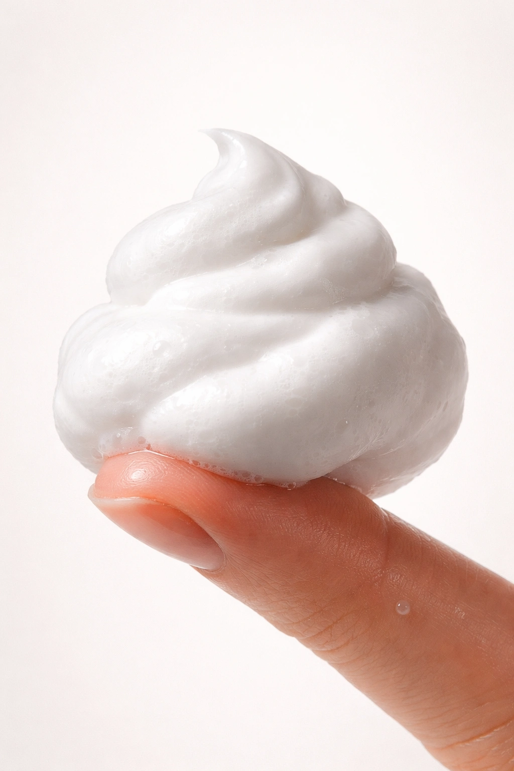 Bead of mousse on fingertip illustrating common mousse application mistakes
