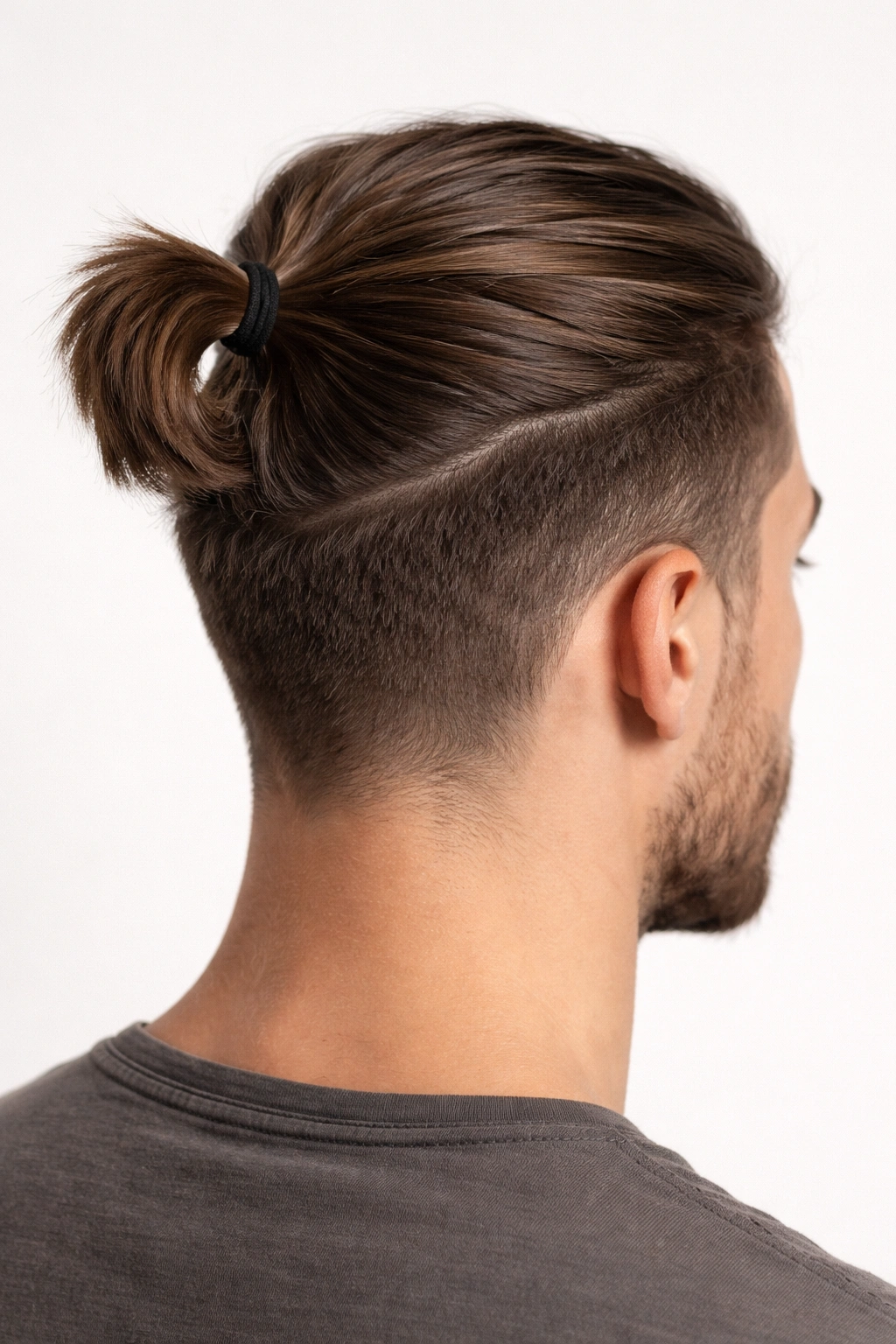 Close-up of a man with a 2-3 inch short ponytail high on the head