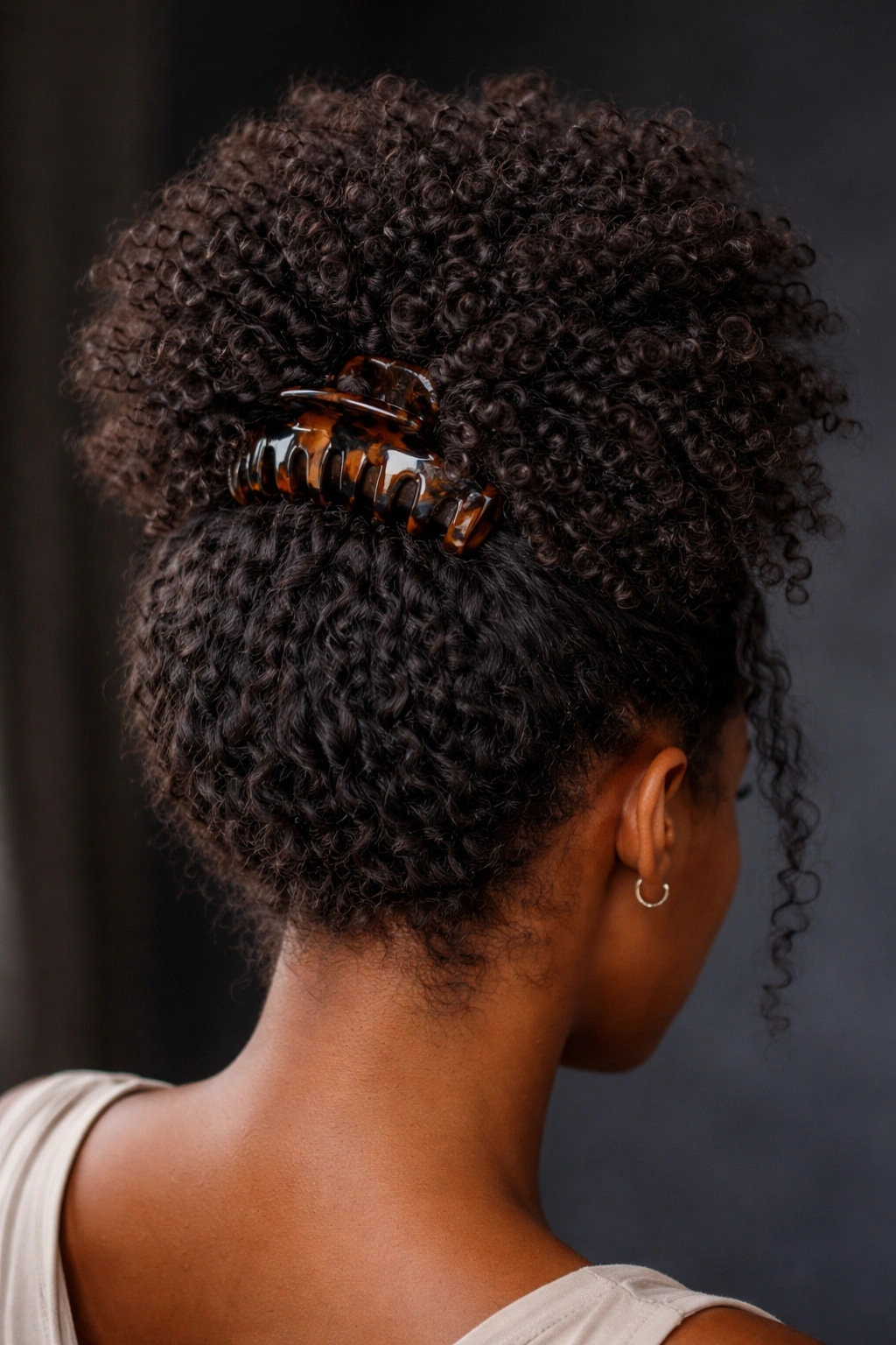 Close-up of textured crown poof with claw clip securing natural Black hair