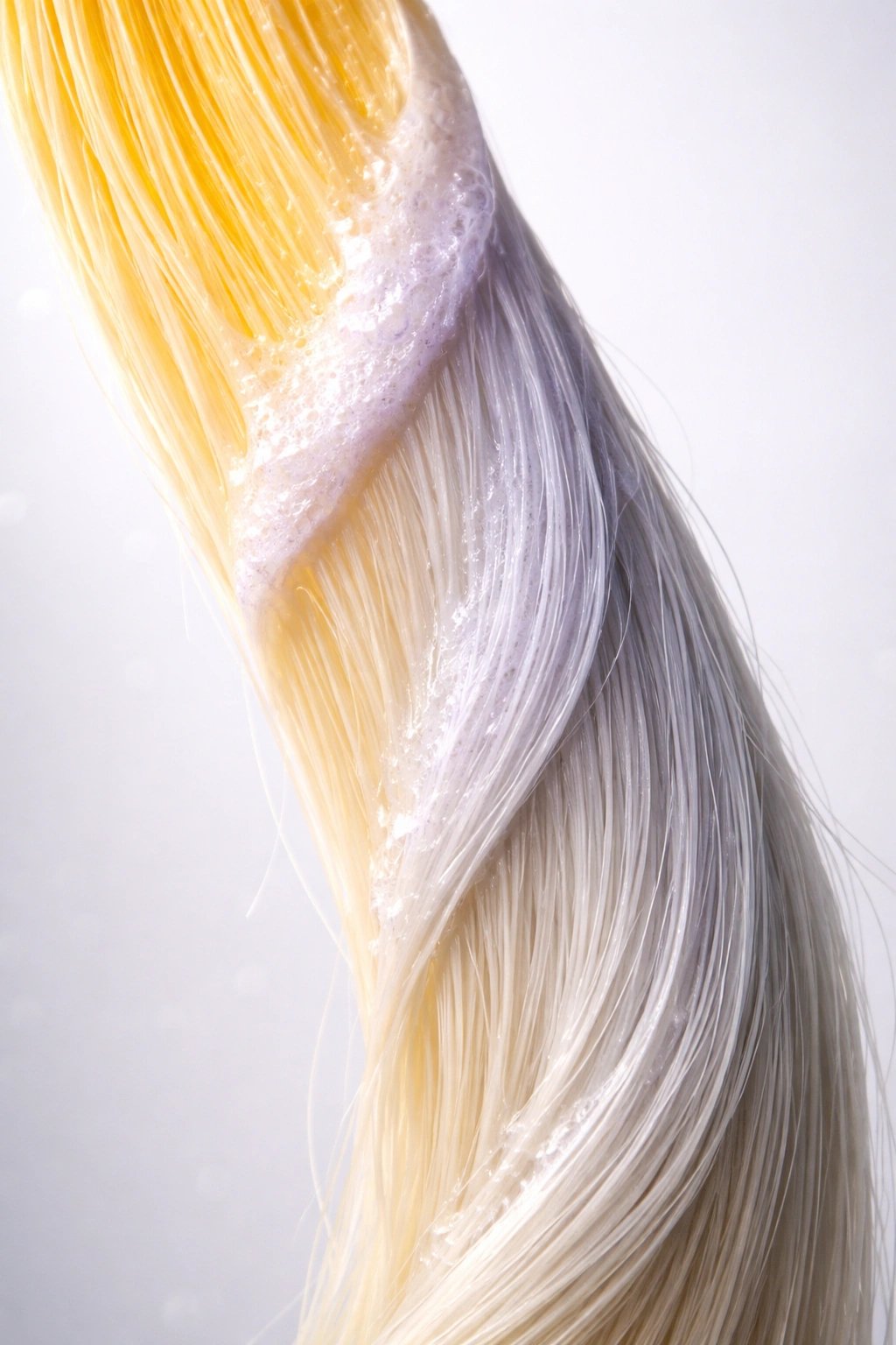 Hair strand showing color shift from yellow to cool shade to indicate toner processing time