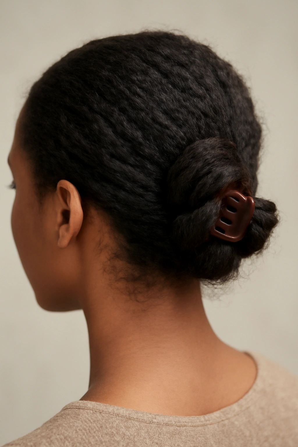 10 Claw Clip Hairstyles That Work for Black Hair 8 Back view of a side-swept twisted knot secured with a claw clip
