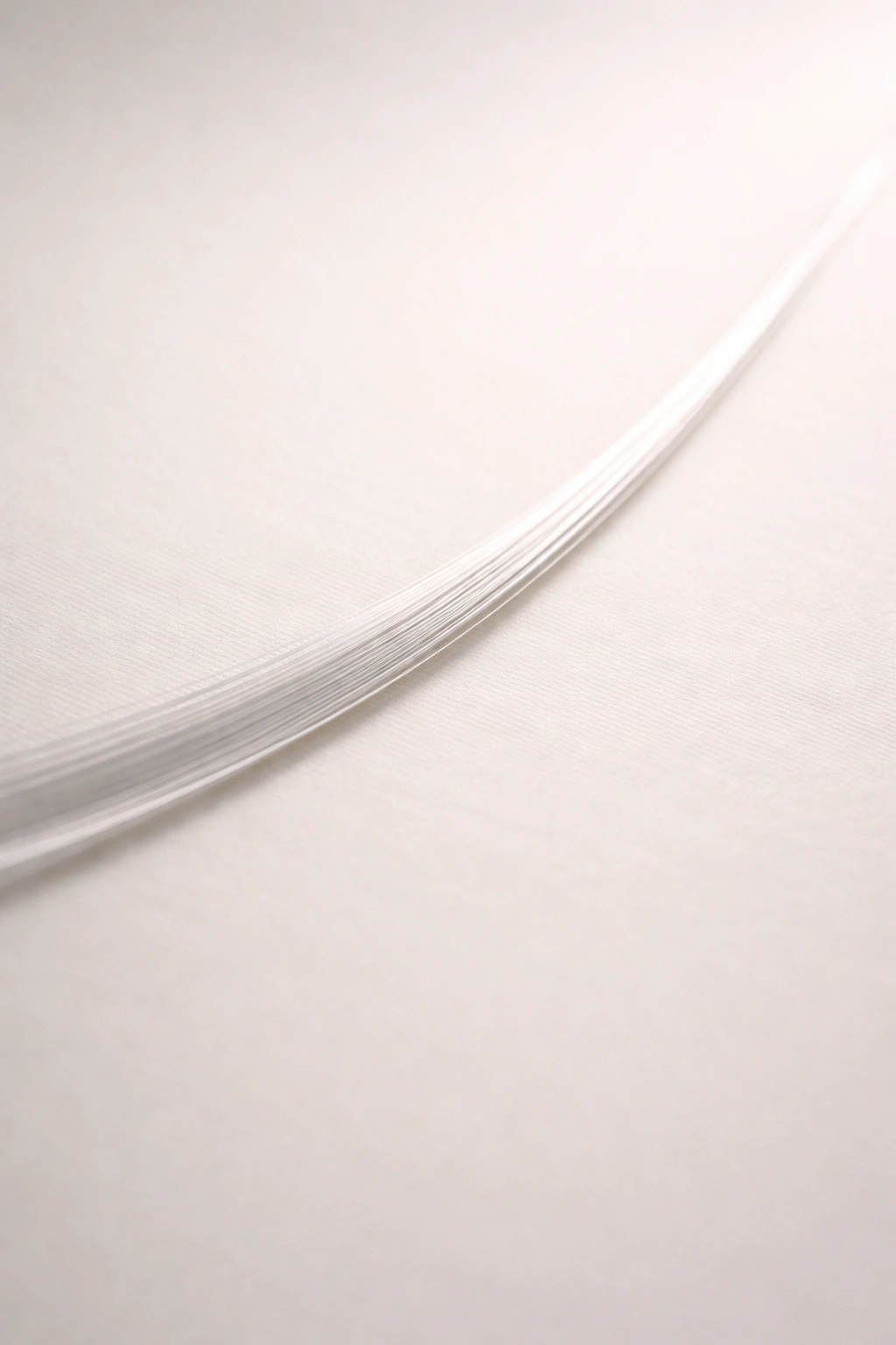 Close-up of ultra-fine straight hair strand (Type 1A) with a glossy shine