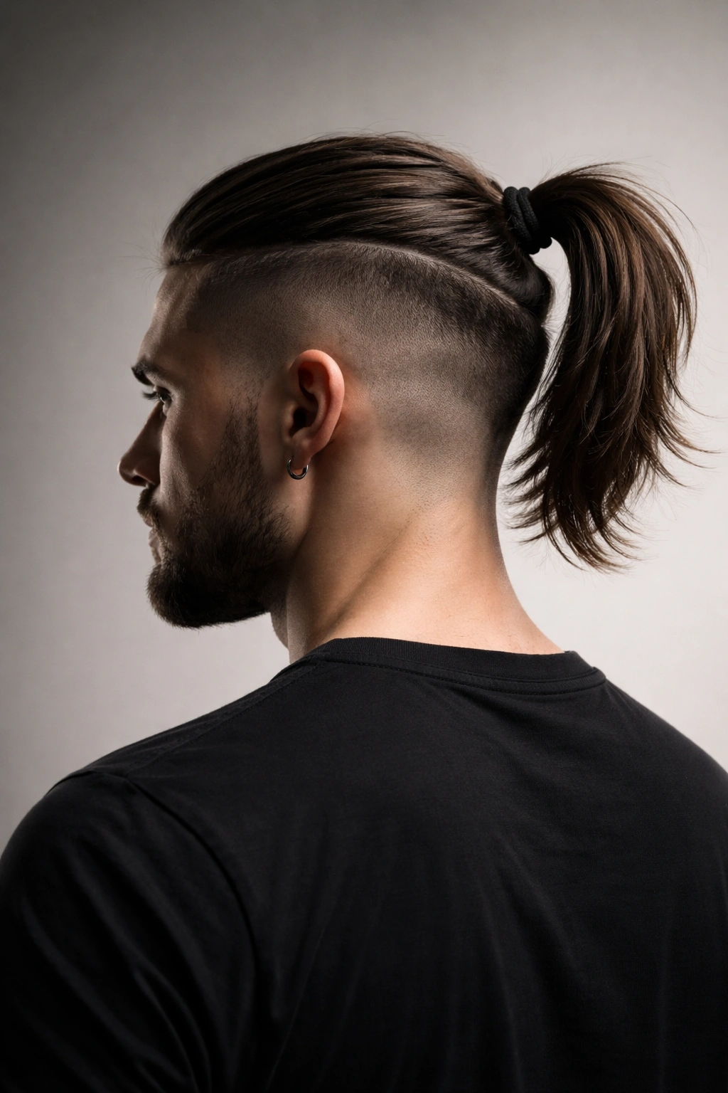 Side view of a man with an undercut and ponytail